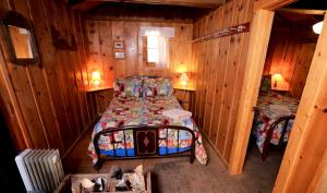 a bedroom with a bed in a wooden cabin at Charming Cabin Rental near Hot Springs in Howelsen Hill Ski Area, Colorado in Columbine