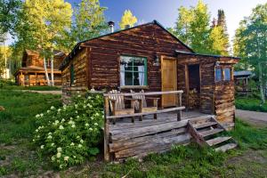 a small log cabin with a porch and a door at Charming Cabin Rental near Hot Springs in Howelsen Hill Ski Area, Colorado in Columbine