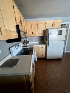 une cuisine avec des appareils électroménagers blancs et des armoires en bois dans l'établissement Spacious Vacation Home with Madison River Frontage near Yellowstone in Ennis, Montana, à Cliff Lake