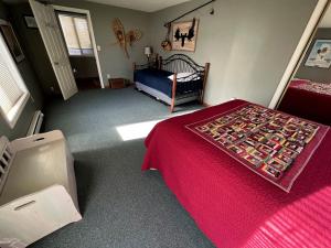 une chambre avec un lit avec un couvre-lit rouge dans l'établissement Spacious Vacation Home with Madison River Frontage near Yellowstone in Ennis, Montana, à Cliff Lake