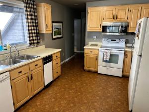 une cuisine avec des appareils électroménagers blancs et des armoires en bois dans l'établissement Spacious Vacation Home with Madison River Frontage near Yellowstone in Ennis, Montana, à Cliff Lake