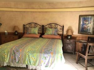 a bedroom with a large bed with a colorful bedspread at Peaceful Vacation Suite Rental Overlooking Mescal Canyon in Clarkdale, Arizona in Jerome