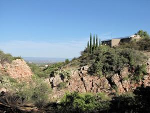 a house on top of a rocky hill with trees at Peaceful Vacation Suite Rental Overlooking Mescal Canyon in Clarkdale, Arizona in Jerome