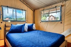 a bed in a room with two windows at Glorious Tented Cabin with Fire Pit and Gorgeous Sky Views in Sevierville, Tennessee in Wear Valley