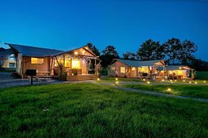 a house with lights in the yard at night at Glorious Tented Cabin with Fire Pit and Gorgeous Sky Views in Sevierville, Tennessee in Wear Valley