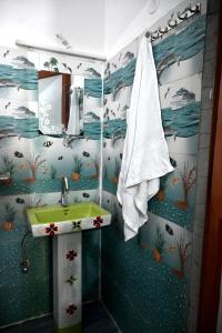 a bathroom with a green sink and a towel at maa kalishila home stay in Ukhimath