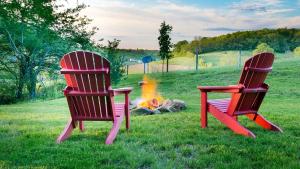 two chairs sitting next to a camp fire at Beautiful Countryside Cabin with Hot-Tub and Pond Views in Ohio in Walnut Creek