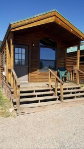 a log cabin with a porch and stairs to the door at Gorgeous Cabin with Stunning Views in West Yellowstone, Montana in Lakeview