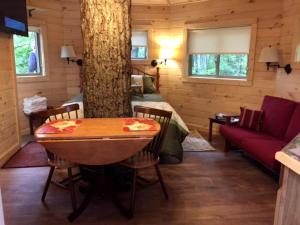 a log cabin with a table and a tree at Stunning Tree House Rental in the Forest near Beckley, West Virginia in Hico