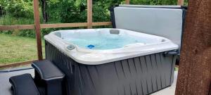 a jacuzzi tub sitting on a patio at Fantastic Cozy Cabin with Fire Pit, Hot-tub and Fireplace in Herod, Illinois in Karbers Ridge
