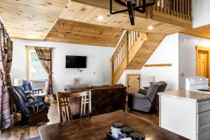 Il comprend une cuisine et un salon avec des plafonds en bois. dans l'établissement Incredible Wooden Cabin with Fire Pit and Barbecue in Greenville, Maine, à Greenville