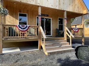 Ce chalet dispose d'une terrasse couverte avec des drapeaux. dans l'établissement Incredible Wooden Cabin with Fire Pit and Barbecue in Greenville, Maine, à Greenville 36 autres photos