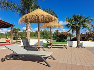 Un grupo de sillas y sombrillas en un patio. en Monte Sossego by Estilo Lusitano, com piscina privada, en Grândola