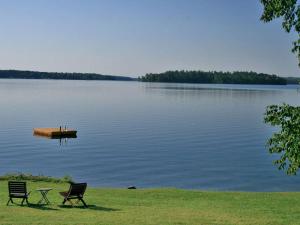 due sedie sedute sull'erba vicino a un lago di Lakeside Cabin Rental for Families near Cohasset, Minnesota a Grand Rapids