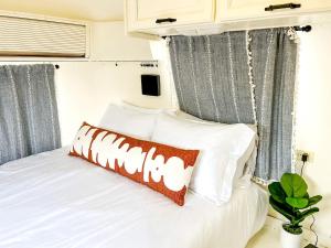 a bedroom with a bed with white pillows at Riverside Airsteram Adventure in Colorado - Relaxation by the Water in Grand Junction in Grand Junction