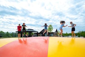 un gruppo di bambini che saltano in cima a una rampa di Breathtaking Family Friendly Tented Cabin in Logan, Ohio a Logan
