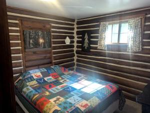 a bedroom with a bed in a log cabin at Enchanting Woodland Cabin Perfect for a Family Getaway on Moose Lake, Wisconsin in New Post