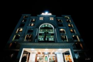 a building with a sign on top of it at night at Daksh The Madhuvan Suites Dwarka in Dwarka