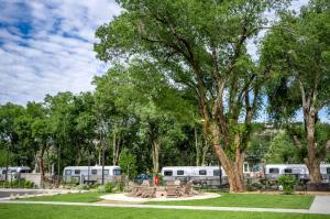 a park with benches and trees with trailers in the background at Airstream Stay Near Whiskey Row and Granite Creek in Prescott, AZ in Prescott