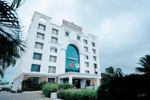 a white building with a sign on it at Daksh The Madhuvan Suites Dwarka in Dwarka