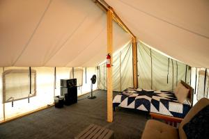 a bedroom in a tent with a bed in it at Cozy Tented Cabin with Fire Pit and Barbecue in Logan, Ohio in Logan