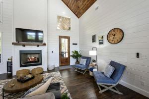 a living room with a fireplace and a clock on the wall at Breathtaking Luxurious Cabin with Fire Pit, Screened Beautiful Porch and Jacuzzi in Oklahoma in Mount Herman