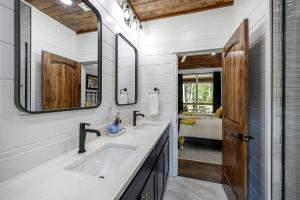 a bathroom with two sinks and a large mirror at Breathtaking Luxurious Cabin with Fire Pit, Screened Beautiful Porch and Jacuzzi in Oklahoma in Mount Herman +60 photos