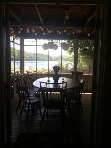 a dining room table with chairs and a vase on it at Cozy Cottage Rental with Lake Views near Okemo State Forest, Vermont in Tyson