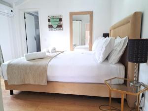 Un dormitorio con una gran cama blanca y una mesa. en Monte Sossego by Estilo Lusitano, com piscina privada, en Grândola 54 fotos más