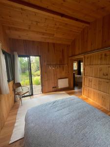 ein Schlafzimmer mit einem Bett in einem Zimmer mit Holzwänden in der Unterkunft Charmant Chalet au bord du lac in Lacanau