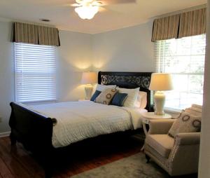 a bedroom with a bed and a chair and windows at Classic Cottage Rental on Huge Horse and Cattle Farm near Charlottesville in Gordonsville