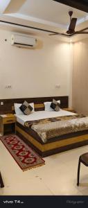 een slaapkamer met 2 bedden en een tapijt bij Shree Radha Raman Palace in Ayodhya