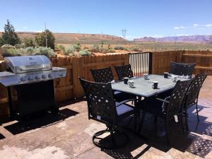 einen Tisch mit Stühlen und einen Grill auf einer Terrasse in der Unterkunft Large Family Retreat in Page, Arizona, Perfect for a Weekend Getaway for Large Groups in Page