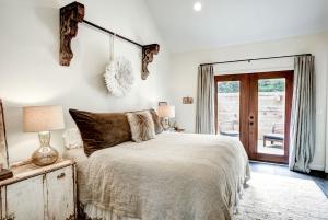 a bedroom with a bed and a sliding glass door at Modern Luxury Rental with Bohemian Decor near Antique Show in Round Top, Texas in Round Top