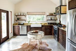 a kitchen with a table in the middle of it at Modern Luxury Rental with Bohemian Decor near Antique Show in Round Top, Texas in Round Top +7 photos