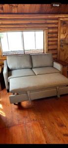 - un canapé installé devant une fenêtre dans une pièce dans l'établissement Charming Lakeside Cabin Bungalow with Timeless Rustic Beauty near Portage Lake in Maine, à Portage Lake Municipal Seaplane Base
