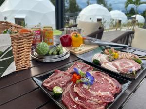 a table with two trays of meat and vegetables at glampark Sesoko -Ocean Terrace- in Sesoko