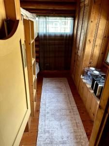 un couloir vide d'une maison avec une cuisine dans l'établissement Charming Lakeside Cabin Bungalow with Timeless Rustic Beauty near Portage Lake in Maine, à Portage Lake Municipal Seaplane Base 1 autre photo