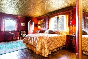 a bedroom with a bed in a room with red walls at Regal Suite Rental in Breathtaking Castle near Lake George, Upstate New York in Bolton Landing