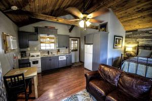 a living room with a couch and a kitchen at Blue Bird Cabin with Hot Tub in Texas Hill Country in Woodcreek