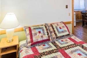 a bedroom with a bed with pillows and a lamp at Private Cabin for Skiing Getaway with Deck in Steamboat Springs, Colorado in Columbine