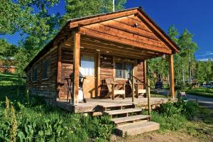 a small wooden cabin with a porch and a table at Private Cabin for Skiing Getaway with Deck in Steamboat Springs, Colorado in Columbine