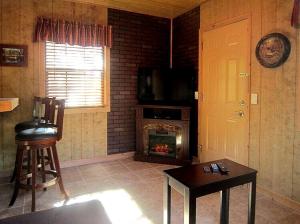 a living room with a fireplace and a table at Rustic Cabin Perfect for a Romantic Getaway in Inverness, Florida in Inverness +4 photos