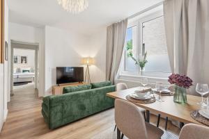 a living room with a green couch and a table at Aparties I Bielefeld mitte I voll ausgestattet I hochwertige Betten I Top Lage in Bielefeld