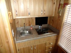 a kitchen with a sink and a stove at Family-Friendly Cabin Surrounded by Small Town Charm in Sundance, Wyoming in Sundance +1 photo