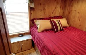 a bedroom with a red bed with a window at Inviting Getaway with a Fireplace near the Black Hills of South Dakota in Sundance