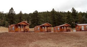 a row of wooden houses in a field at Inviting Getaway with a Fireplace near the Black Hills of South Dakota in Sundance
