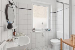 a white bathroom with a sink and a toilet at Aparties I Bielefeld mitte I voll ausgestattet I hochwertige Betten I Top Lage in Bielefeld +36 photos