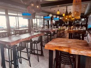 Un bar con mesas y sillas de madera en un restaurante. en The Blyde Inn, en Pretoria