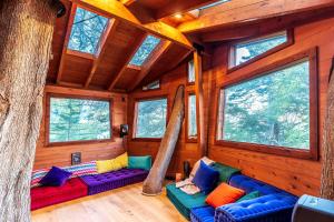Una habitación con sofás coloridos en una cabaña con ventanas. en Half Moon Bay Glamping Getaway in an Idyllic Tree House and Cabin, en Half Moon Bay